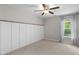 Cozy bedroom featuring wainscoting, ceiling fan, and natural light from the window at 333 Gardens Of Harmony Dr, Canton, GA 30115