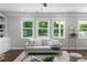 Bright living room features large windows, a neutral sofa, and a cozy rug, creating a relaxing atmosphere at 333 Gardens Of Harmony Dr, Canton, GA 30115