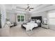 Serene primary bedroom with a tray ceiling, plush bedding, and a cozy sitting area, offering a peaceful escape at 333 Gardens Of Harmony Dr, Canton, GA 30115