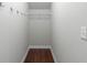 Bare walk-in closet with wooden floors, coat hooks and a single shelf at 333 Gardens Of Harmony Dr, Canton, GA 30115