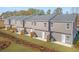 Rear view of townhomes with manicured lawns and fenced patios, perfect for outdoor living at 109 Meadowview Dr, Temple, GA 30179