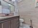 Charming bathroom with wood wall, granite countertop, copper sink, vintage-style mirror, and toilet at 215 Little Brook Ln, Woodstock, GA 30188