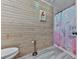Bathroom featuring wood paneling, a whimsical shower curtain, and updated fixtures at 215 Little Brook Ln, Woodstock, GA 30188