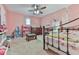 Pink bedroom featuring dollhouse, black iron bed frame and white birch tree wall decals at 215 Little Brook Ln, Woodstock, GA 30188