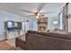 Cozy living room featuring a stone fireplace, ceiling fan and comfortable seating with lots of light at 215 Little Brook Ln, Woodstock, GA 30188