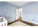 Bedroom showcasing blue walls, hardwood floors, a charming changing table, and ample space at 2792 Mathews Se St, Smyrna, GA 30080