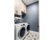 Modern laundry room with patterned tile and front loading washer and dryer at 2792 Mathews Se St, Smyrna, GA 30080