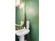 Charming powder room features a pedestal sink and a gold-trimmed mirror at 2792 Mathews Se St, Smyrna, GA 30080