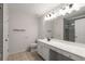 Well-lit bathroom with a toilet, vanity, sink, large mirror, and a glass-enclosed shower at 3626 Lantern Crest Cv, Scottdale, GA 30079