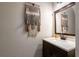 Stylish half bathroom with modern vanity, neutral wall color, and decorative tapestry at 3626 Lantern Crest Cv, Scottdale, GA 30079