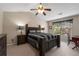 A bedroom features a ceiling fan, a window with curtains, and a dark-colored bed set at 3626 Lantern Crest Cv, Scottdale, GA 30079