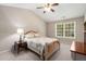 Bright bedroom with a ceiling fan, a large window, and neutral-toned walls and carpet at 3626 Lantern Crest Cv, Scottdale, GA 30079