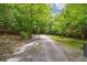 Long gravel driveway leading to a secluded property surrounded by lush trees and greenery at 909 Wentworth Ct, Alpharetta, GA 30022