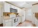 Well-lit kitchen featuring white appliances, cabinets, and mosaic tile accents at 909 Wentworth Ct, Alpharetta, GA 30022