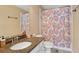 Well-lit bathroom with a granite countertop, a patterned shower curtain and vanity mirror at 1029 Ector Nw Dr, Kennesaw, GA 30152