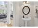Elegant powder room with a pedestal sink, decorative mirror, and stylish lighting at 1029 Ector Nw Dr, Kennesaw, GA 30152