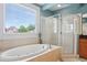 Bright bathroom boasts a soaking tub, glass-enclosed shower, and a large window for natural light at 1029 Ector Nw Dr, Kennesaw, GA 30152