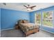 Comfortable bedroom boasts a ceiling fan, neutral carpeting, and large windows offering natural light at 1029 Ector Nw Dr, Kennesaw, GA 30152