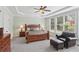 Spacious main bedroom featuring tray ceilings, neutral carpeting, ceiling fan, and large windows at 1029 Ector Nw Dr, Kennesaw, GA 30152
