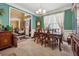 Formal dining room boasts elegant dark wood furnishings, a decorative chandelier, and bright light at 2372 Wilshire Way, Douglasville, GA 30135