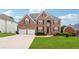 Inviting two-story brick home with attached two-car garage, red shutters and a meticulously maintained lawn at 2372 Wilshire Way, Douglasville, GA 30135