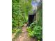 A verdant backyard features a staircase leading to a higher deck, surrounded by mature trees and shrubbery at 312 Stonemont Dr, Atlanta, GA 30305