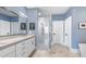 A bright bathroom with double sinks, blue walls, and a glass walk-in shower at 312 Stonemont Dr, Atlanta, GA 30305