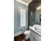 A modern powder room with black subway tile, floating vanity, and statement mirror at 312 Stonemont Dr, Atlanta, GA 30305
