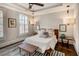Cozy bedroom with a tray ceiling, a bench, and a luxurious bed with neutral tones at 312 Stonemont Dr, Atlanta, GA 30305