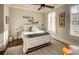 A naturally lit bedroom has a decorative ceiling fan, neutral walls, striped bedding, and minimalist decor at 312 Stonemont Dr, Atlanta, GA 30305