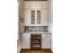 A beautifully designed butler's pantry with white cabinets, a wine fridge, and herringbone backsplash at 312 Stonemont Dr, Atlanta, GA 30305