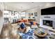 Open-concept living room and kitchen featuring a fireplace, modern furnishings, and hardwood floors at 312 Stonemont Dr, Atlanta, GA 30305