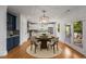 Elegant dining area with stylish lighting fixture and hardwood floors, open to kitchen at 3123 Cedar St, Scottdale, GA 30079