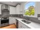 This kitchen features stainless steel appliances, a modern range hood and stone backsplash with quartz countertops at 3123 Cedar St, Scottdale, GA 30079