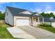 Attractive home exterior with a two-car garage, brick accents, and a long driveway at 423 Murphy Ave, Canton, GA 30114