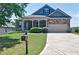 Charming home with a well-manicured lawn, covered porch, and a mix of brick and stone facade at 514 Creekshire Cir, Canton, GA 30115