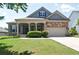 Charming single-Gathering home featuring a well-manicured lawn, stone accents, and a welcoming front porch at 514 Creekshire Cir, Canton, GA 30115