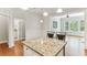Kitchen island with granite countertops and seating, adjacent to bright, open living space at 11 Perimeter E Ctr # 1402, Dunwoody, GA 30346