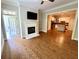Living room with fireplace, television, hardwood floors and view into kitchen with island at 11 Perimeter E Ctr # 1402, Dunwoody, GA 30346