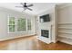 Bright living room featuring a fireplace, built-in shelves, hardwood floors, and large windows at 11 Perimeter E Ctr # 1402, Dunwoody, GA 30346