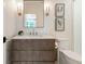Elegant bathroom with a modern vanity, marble countertop, framed mirror, sconces, and toilet at 1191 W Conway Dr, Atlanta, GA 30327