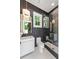 Modern bathroom featuring a glass enclosed shower, dark patterned tiles, and a white vanity with modern fixtures at 1191 W Conway Dr, Atlanta, GA 30327