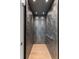 Residential elevator interior features dark, geometric patterned walls and light-colored hardwood flooring at 1191 W Conway Dr, Atlanta, GA 30327