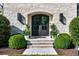Elegant stone entryway featuring a black double door framed by lush greenery and stylish outdoor lighting at 1191 W Conway Dr, Atlanta, GA 30327