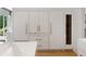 Kitchen featuring a wine fridge, white cabinets, and an island with marble countertop at 1191 W Conway Dr, Atlanta, GA 30327
