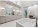 Main bathroom with dual vanity, modern lighting, soaking tub and separate shower with glass enclosure at 1191 W Conway Dr, Atlanta, GA 30327