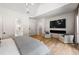 Bright main bedroom featuring hardwood floors, a modern fireplace with TV, and neutral-colored walls at 1191 W Conway Dr, Atlanta, GA 30327