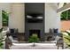 Close up of outdoor fireplace with seating on both sides, a mounted TV and firewood storage underneath at 1191 W Conway Dr, Atlanta, GA 30327