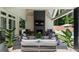 Inviting covered outdoor living space with a brick fireplace, seating, and a view of the pool and surrounding greenery at 1191 W Conway Dr, Atlanta, GA 30327