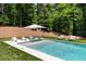 Tranquil backyard pool area with lounge chairs, an umbrella, and verdant landscaping for a serene outdoor experience at 1191 W Conway Dr, Atlanta, GA 30327